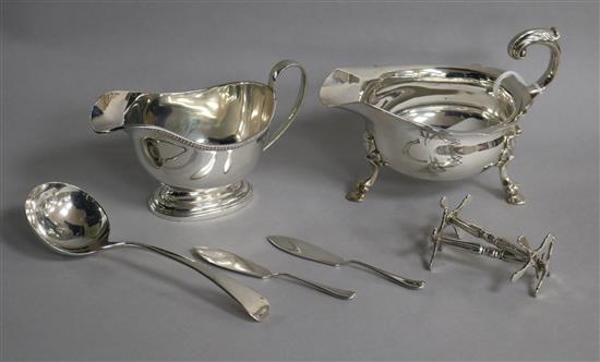 Two silver sauceboats, a pair of Victorian silver knife rests, a George III silver sauce ladle and two silver butter knives.